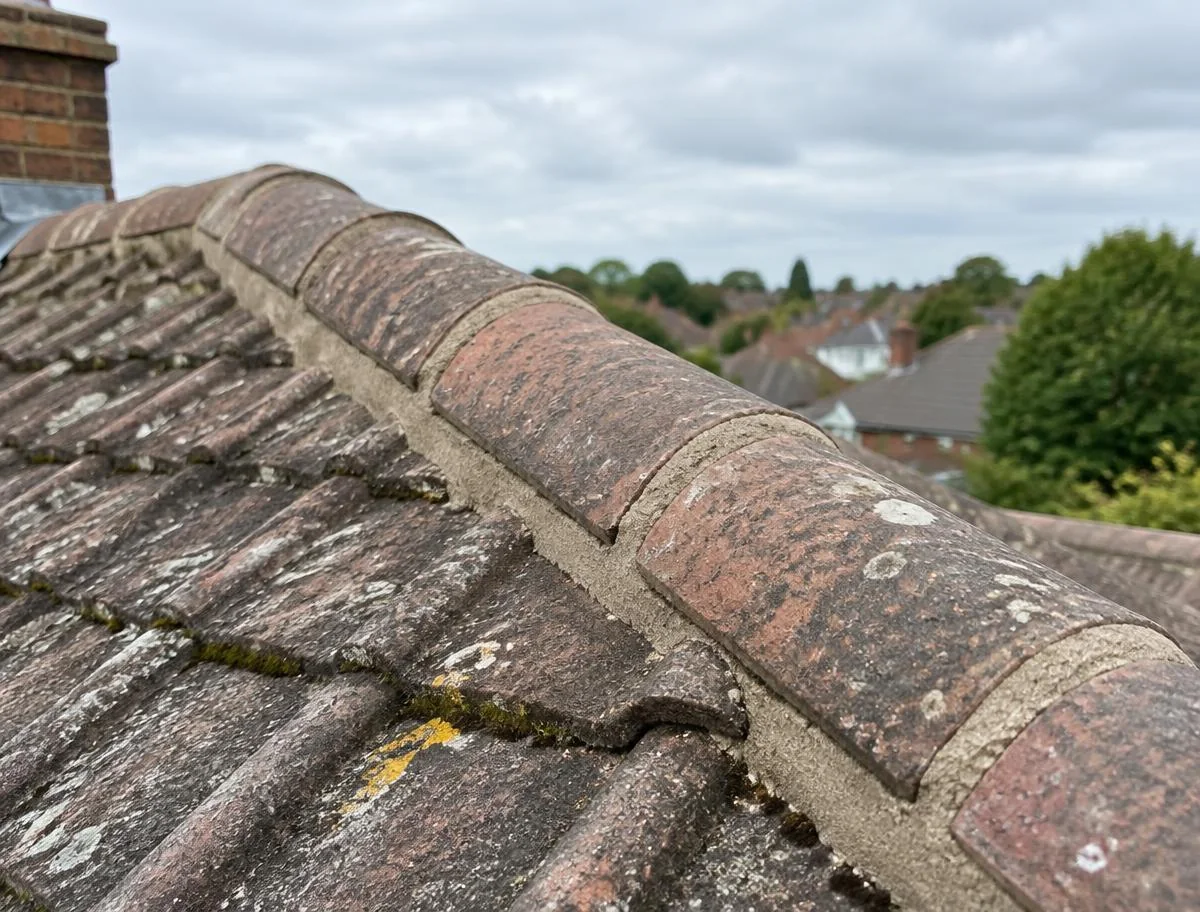 Repaired ridge tiles on a weathered British roof